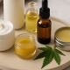 Assorted cannabis-infused topicals, including cream, balm, oil bottles, and a cannabis leaf, arranged neatly on a beige tray for a wellness-themed setting.