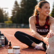 Elite Canadian track athlete stretching during post-training recovery, with CBD oil and recovery products placed beside her on the track.